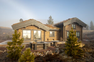 Front view of a compact log cabin with mist rolling in.